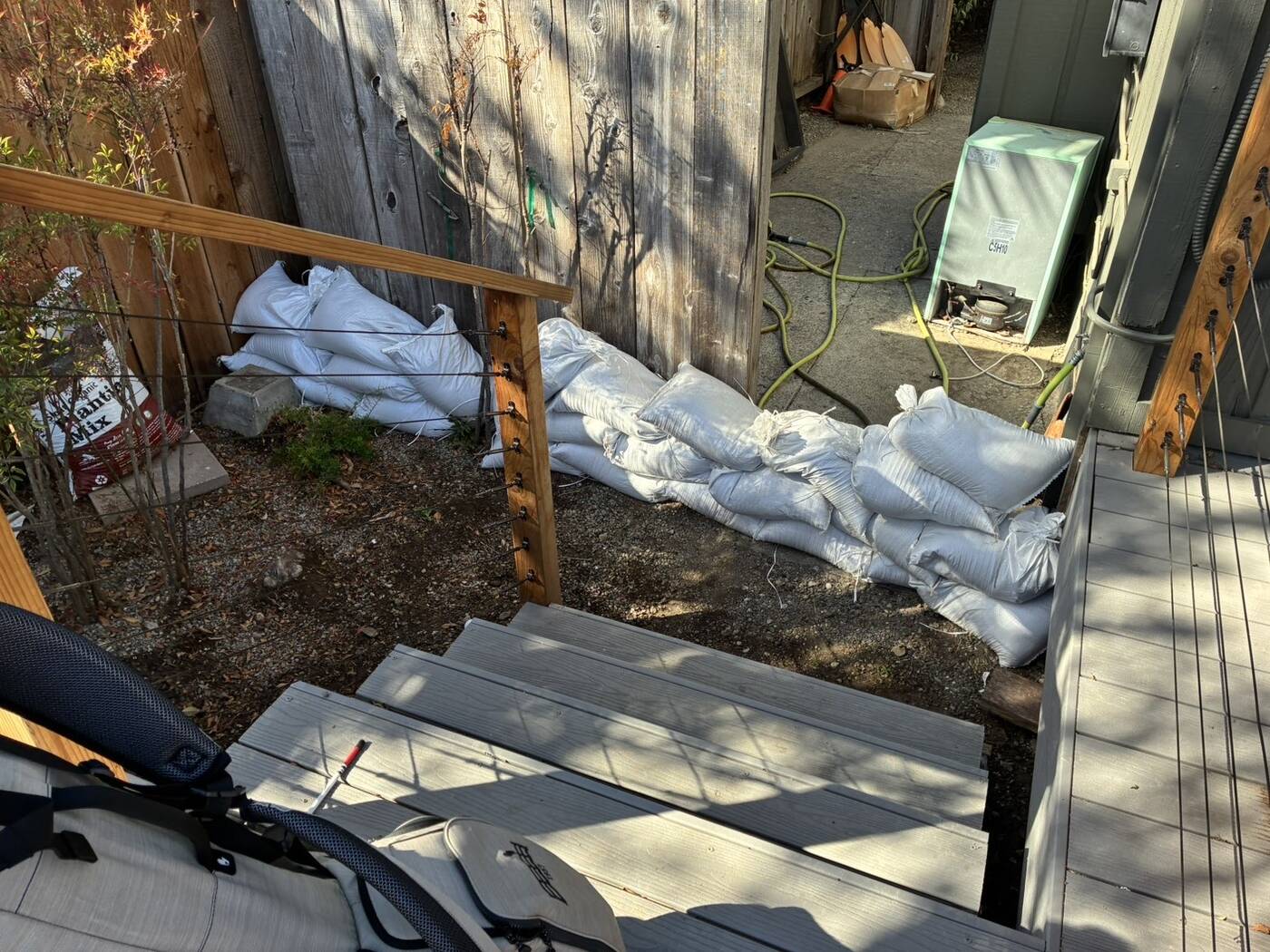 Sandbag run along a fence from the deck to the house
