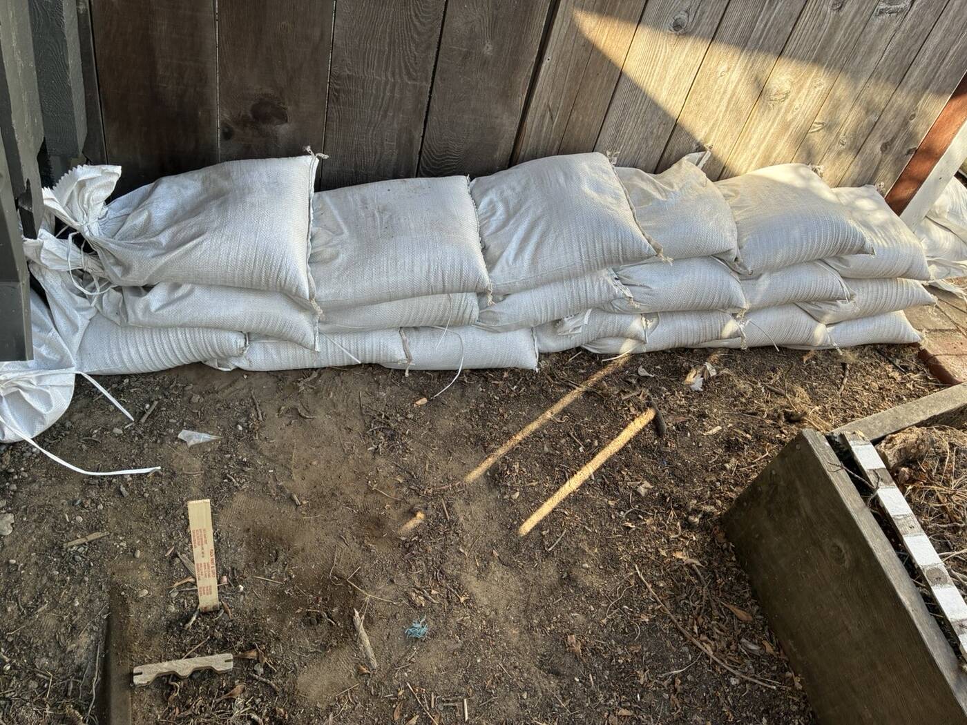 Sandbags three high along a fence